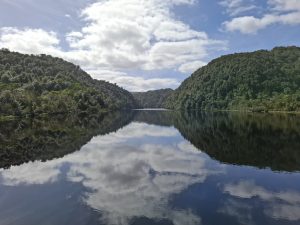 Still mountain lake perfectly reflecting the surrounding landscape — the past mirrored in the present, how inherited beliefs continue to shape adult life